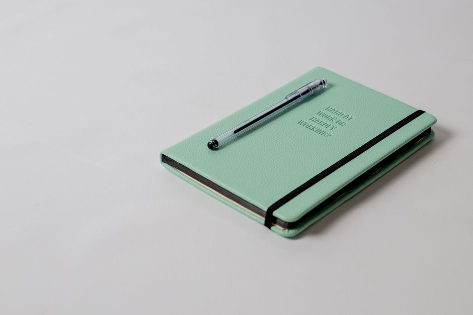 A minimalist mint green notebook and pen, perfect for planning or journaling.