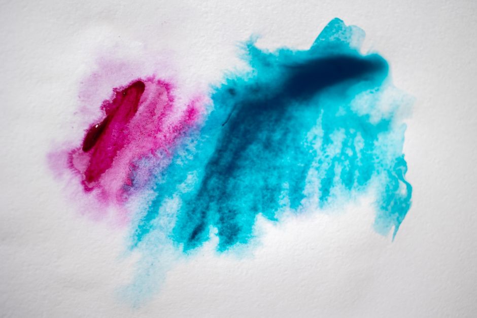 Colorful abstract watercolor splashes on white paper showcasing vibrant artistic expression.